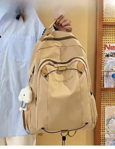 Detailed view of cream nylon backpack on model showing size ratio and plush cloud charm