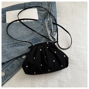 Détail du mini sac nuage noir avec motif floral blanc sur tissu denim