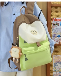 Detail view of contrast color backpack with a cute plush toast pendant and fashion logo