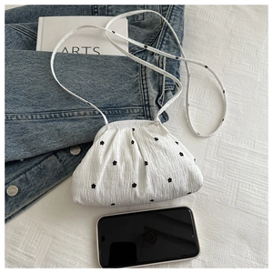 Détail du mini sac bandoulière blanc plissé avec broderies de petites fleurs noires