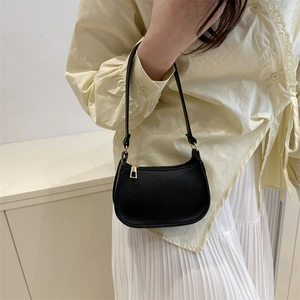 Minimalistische schwarze Schultertasche aus genarbtem Leder mit goldenen Metalldetails