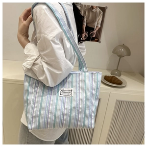 Close-up of a striped canvas tote bag showing the textured fabric and textile logo