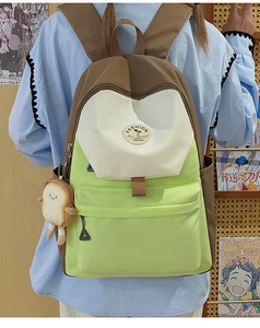 Detail of color-block canvas backpack featuring a toast plush charm and fashion patch