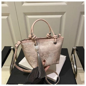 Detail of Chinese style embroidered bucket bag with silk landscape and tassel charm