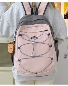 Vue de dos d'un sac à dos rose et gris avec cordons élastiques et breloque biscuit