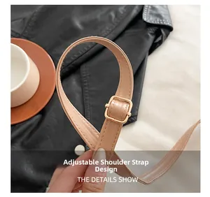 Detail des verstellbaren beigen Lederriemens mit goldener Metallschnalle der Handtasche
