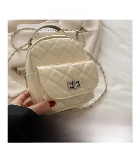Detail of quilted mini handbag with silver twist lock and woven metal chain strap