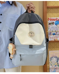 Detail of color-block school backpack with toast plush charm and water-resistant nylon