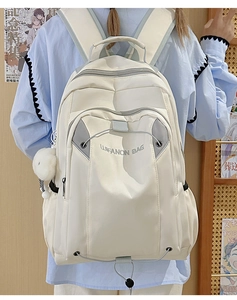 White nylon backpack with multiple compartments and a plush ball charm for students