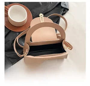 Draufsicht der beigen Handtasche mit geräumigem Innenfach und goldenem Drehverschluss
