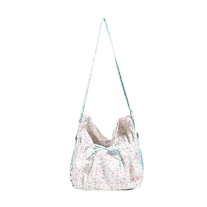 Floral canvas backpack with pink flower patterns and blue checkered drawstring accents