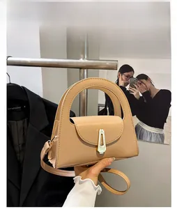 Detail der khakifarbenen Ledertasche mit goldener Schnalle und abnehmbarem Gurt