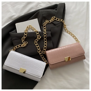 Dettaglio di borse con patta motivo coccodrillo e catena dorata in bianco e rosa cipria