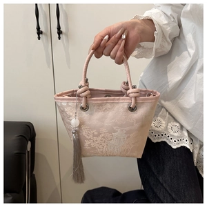 Detail of pink embroidered bucket bag with Chinese landscape art and long tassel charm