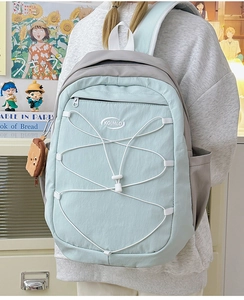 Détail du sac à dos bleu et gris avec cordon élastique croisé et porte-clés toast peluche
