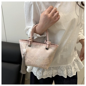 Detail of pink embroidered bucket bag with oriental patterns and long tassel pendant