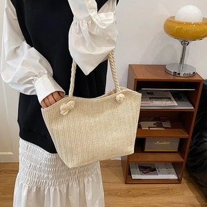 Handmade woven straw handbag with thick rope handles and stylish herringbone pattern