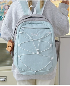 Sac à dos bleu clair et gris avec système de cordon élastique et breloque peluche pain