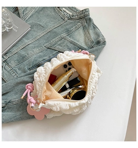 Detail view of white bubble puff shoulder bag showing interior capacity and pink flower charm