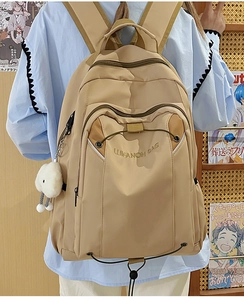 Rear view of a khaki large capacity nylon backpack with a plush cloud pendant and side pockets