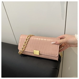 Dettaglio borsa rosa con trama a pietra, catena dorata spessa e fibbia in metallo