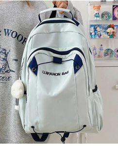 Close-up of light blue nylon backpack with LIFANON embroidery and white plush pendant