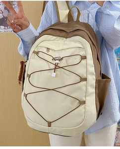 Détail du sac à dos bicolore avec cordons élastiques et mini pochette zippée assortie