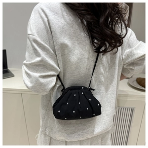 Gros plan détaillé d'un sac cabas à fleurs noir porté par un mannequin dans un intérieur
