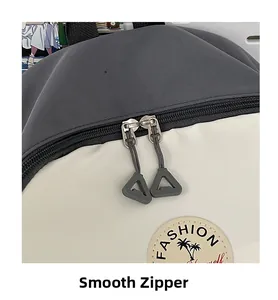 Detail of smooth two-way metal zippers on a color-block canvas backpack for college