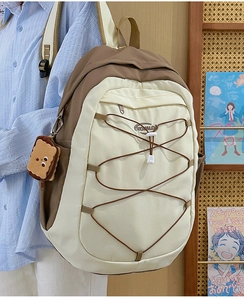 Détail d'un sac à dos bicolore grande capacité avec un pendentif peluche en biscuit