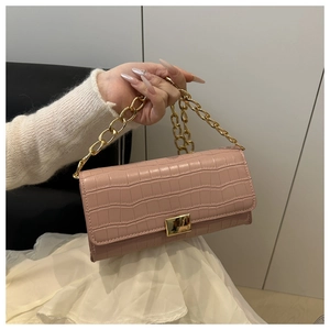 Dettaglio borsa baguette rosa effetto coccodrillo con catena dorata e chiusura in metallo
