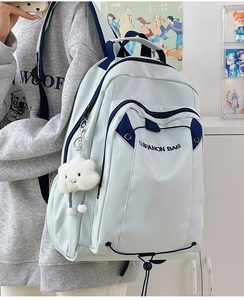 Detail view of large capacity light blue backpack with white cloud plush pendant