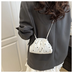 Détail du sac cabas matelassé blanc à motifs fleurs sur mannequin en blazer gris