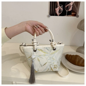Detailed close-up of Chinese style bucket bag with elegant bamboo leaf embroidery and tassel