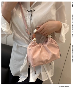 Pink drawstring bucket bag with unique marble texture beaded handle and brand logo detail