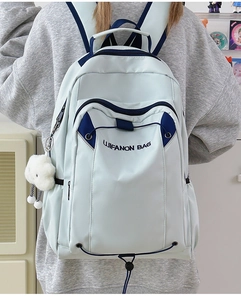 Detail view of large capacity light green backpack with blue trim and plush cloud charm
