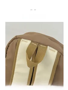 Détail du sac à dos kaki et crème montrant la poignée supérieure et les coutures
