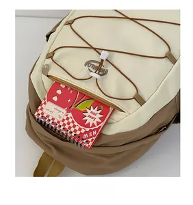 Détail de la poche avant contrastée avec cordon de rangement sur le sac à dos