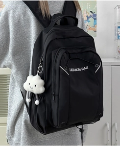 Rear view of black waterproof nylon backpack with white cloud plush pendant and logo