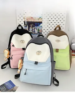 Detailed view of color-block backpacks in pink, blue, and green with plush toast charms