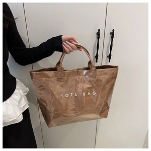 Détail d'un cabas marron avec couche en PVC imperméable et texte blanc sur la surface