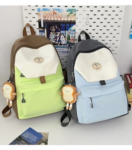 Detail of color-block nylon backpack with plush charm and fashion label for students