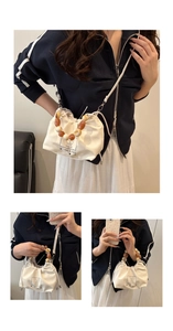 Detail of cream canvas bucket bag with colorful beaded handle and brand woven label