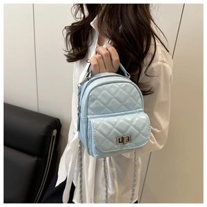 Detail eines hellblauen gesteppten Mini-Rucksacks mit silbernen Kettenriemen und Verschluss
