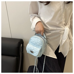 Detail der hellblauen gesteppten Mini-Rucksacktasche mit silbernem Drehverschluss und Kette
