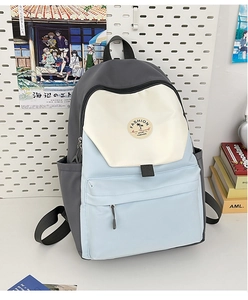 Detail of color-block nylon backpack with side pocket and trendy round badge decoration