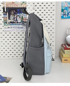 Detail view of the tricolor nylon backpack showing side pockets and padded shoulder straps