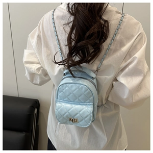 Detail eines hellblauen gesteppten Mini-Rucksacks aus Lackleder mit silbernem Drehverschluss