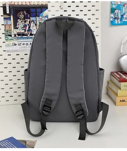 Detail of dark grey waterproof backpack with adjustable straps and side pocket on desk