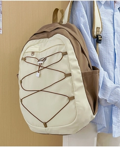 Vue latérale d'un sac à dos cargo crème et marron avec cordons élastiques réglables